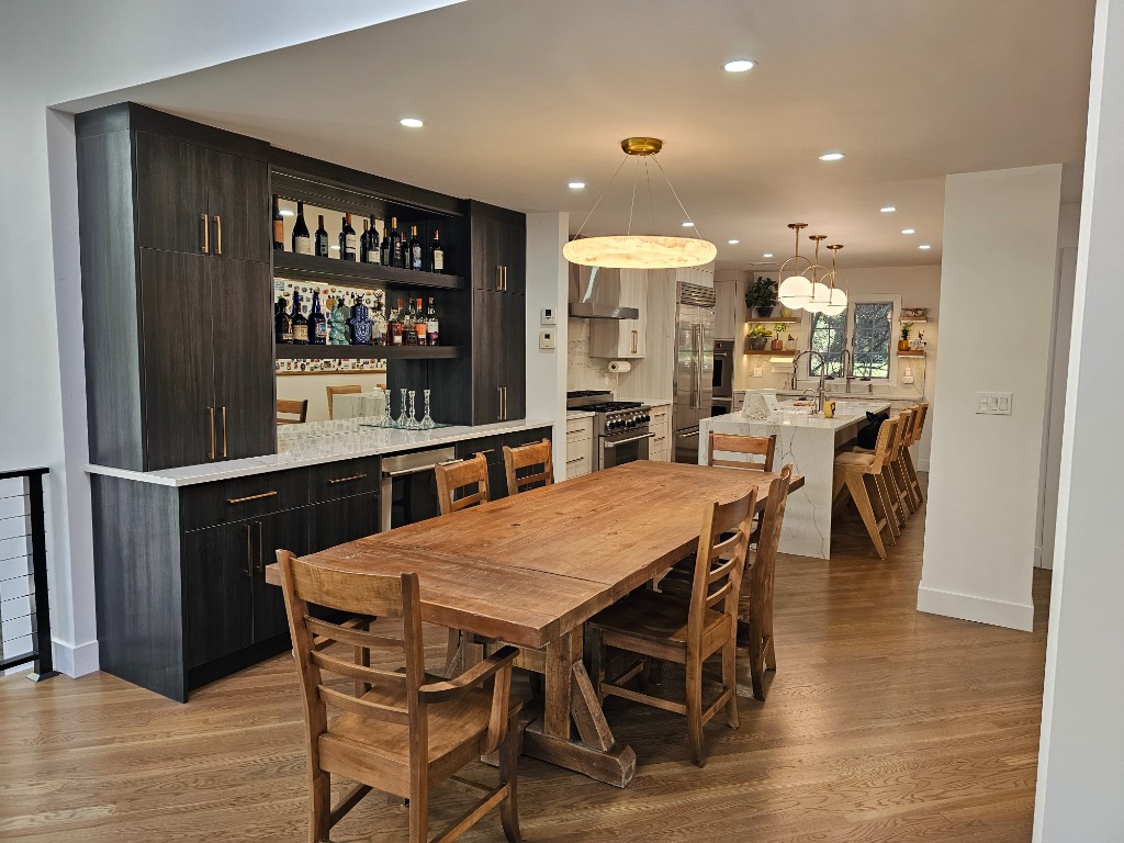 Dark grey cabinetry and wooden dining table in a rustic modern setting
