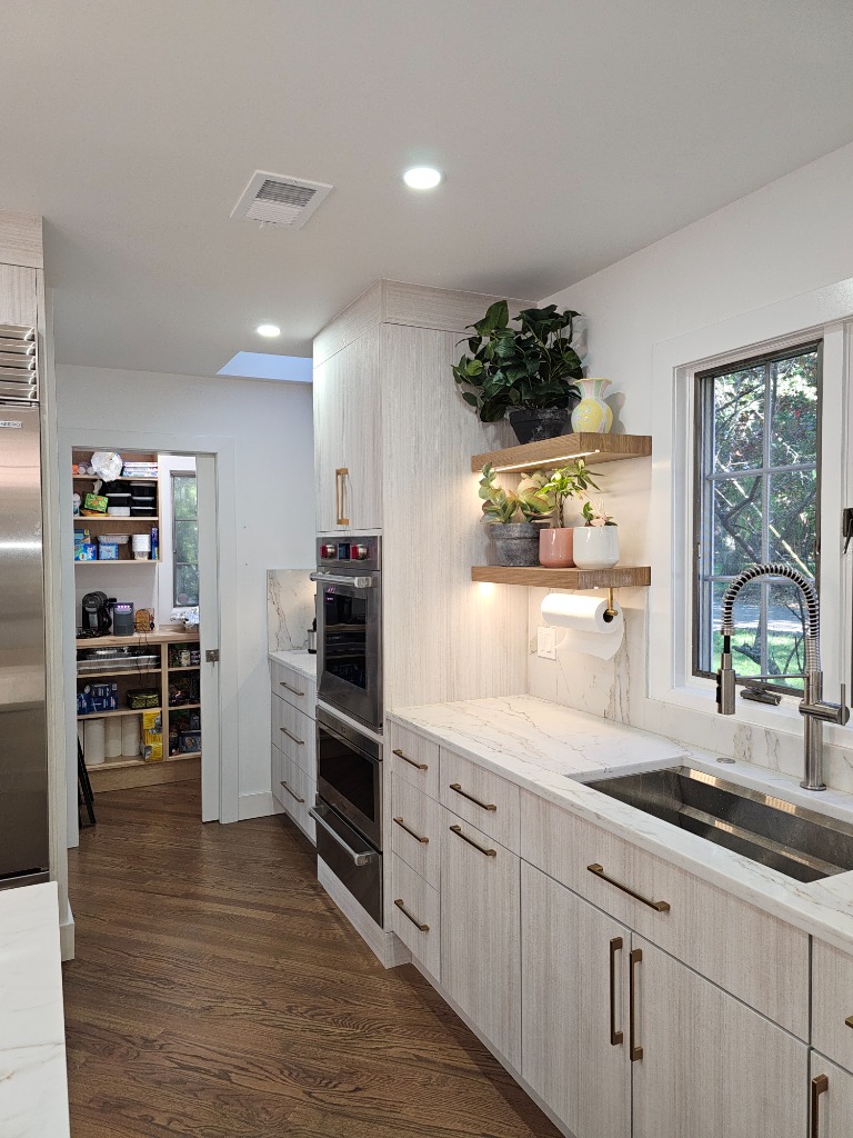Modern wood grain kitchen with visible pantry and greenery